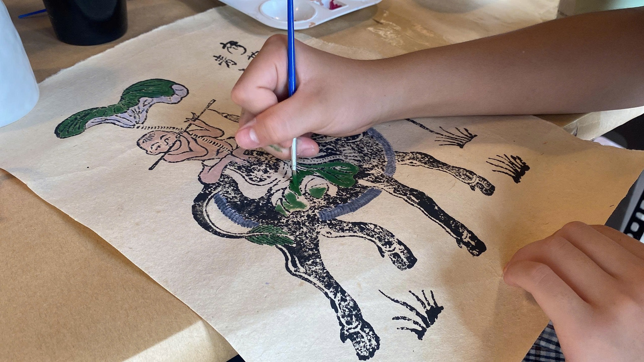 Visitors creating colorful Dong Ho folk paintings on traditional Do paper at Ho Van Cultural Space in Hanoi.